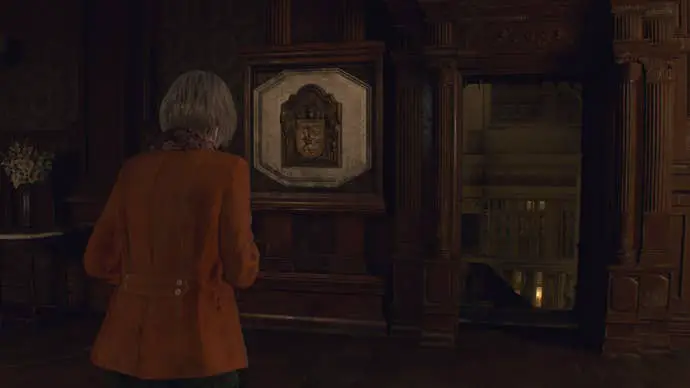 Ashley se enfrenta a una puerta abierta tras colocar el escudo de la familia Salazar en Resident Evil 4 Remake