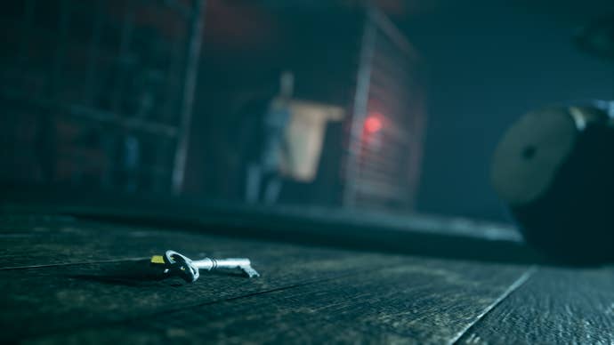 Una llave es visible en el suelo con un personaje en la distancia.